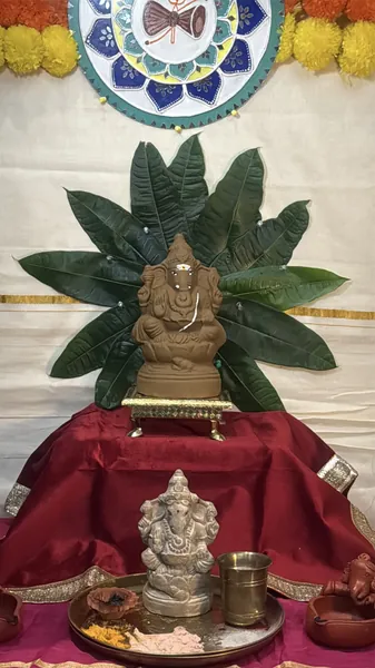 Ganesh Chaturthi home altar with a plantable clay Ganesha idol, marigolds and puja items